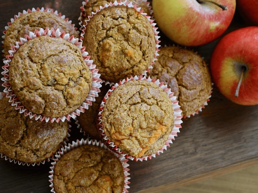 Vegan-apple-cinnamon-muffins-in-red-liners-with-fresh-apples